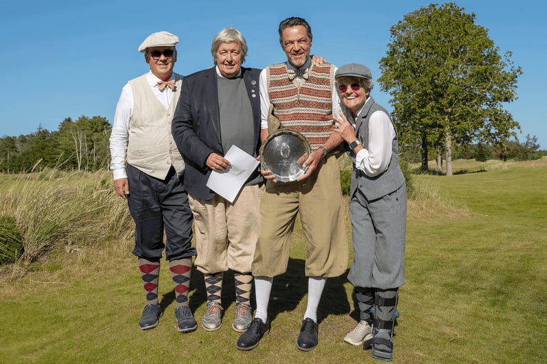 Paolo Quirici smiling and posing with a silver trophy plate, surrounded by fellow players in traditional golf attire, at the German Open Hickory Championship 2025.