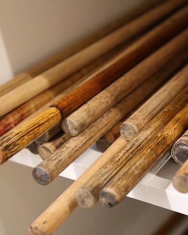 Close-up of original hickory golf club shafts showing the natural grain and signs of age.